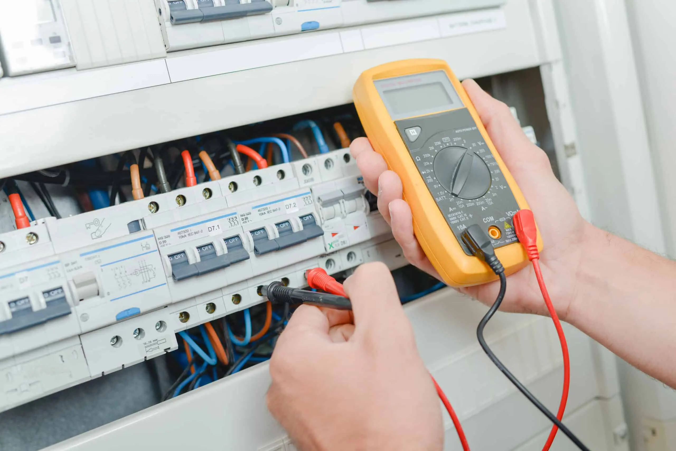 Electrician testing electrical current during fixed wire testing.